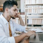 Student working on first freelance project from home while communicating with online client